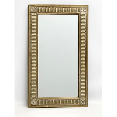 351 - An Early 20th Century brass framed mirror. 36x62cm.