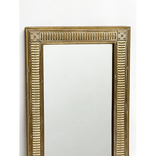 351 - An Early 20th Century brass framed mirror. 36x62cm.