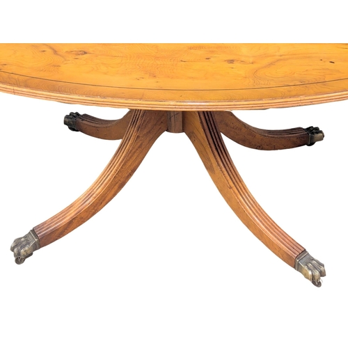 1040 - A Georgian style inlaid yew wood pedestal coffee table on brass lion paw feet. 128x76.5x55cm (3)