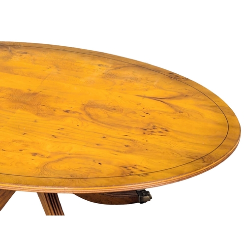 1040 - A Georgian style inlaid yew wood pedestal coffee table on brass lion paw feet. 128x76.5x55cm (3)