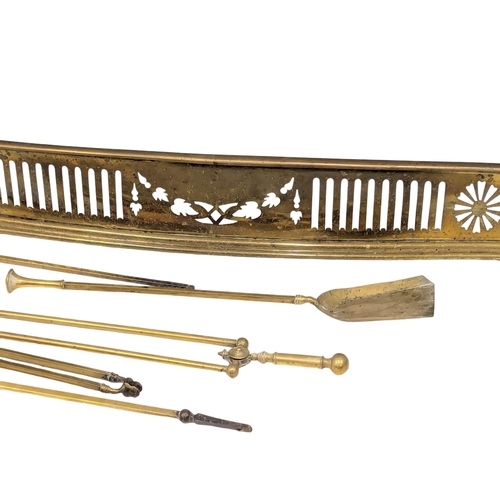 554 - A Late 19th Century brass fire surround with brass fire tools. 140x31.5cm