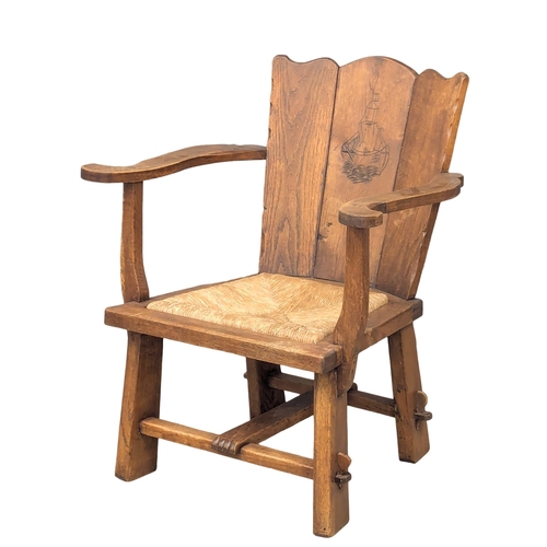 836 - An Early 20th Century oak Arts & Crafts armchair with rush seat. 61x80cm (5)