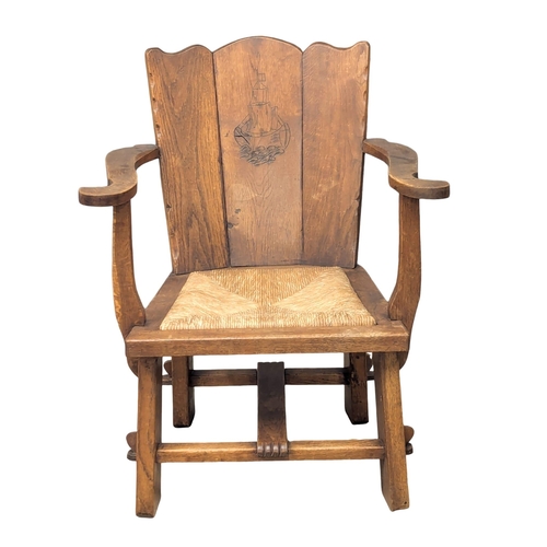 836 - An Early 20th Century oak Arts & Crafts armchair with rush seat. 61x80cm (5)