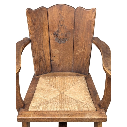 836 - An Early 20th Century oak Arts & Crafts armchair with rush seat. 61x80cm (5)