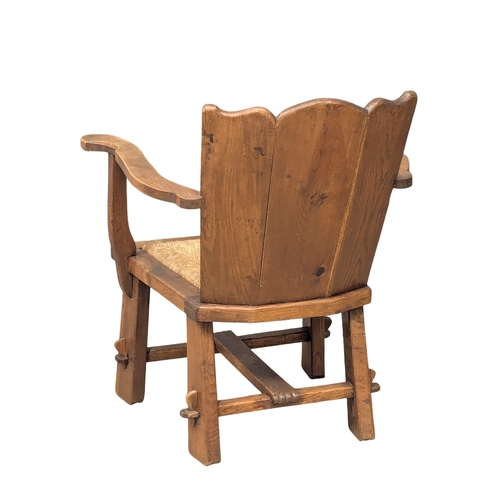 836 - An Early 20th Century oak Arts & Crafts armchair with rush seat. 61x80cm (5)