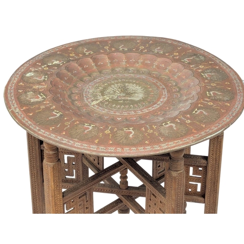 854 - An Early 20th Century Indian engraved brass table with folding teak base. 59.5x54.5cm (2)