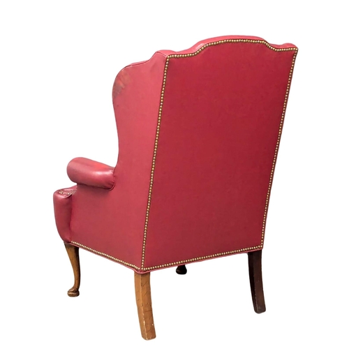 892 - A vintage Georgian style wingback armchair.(6)