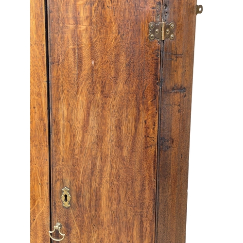 912 - A Late 18th Century George III oak wall hanging corner cupboard with fitted shelves. 65x46x107cm(7)