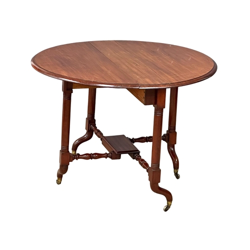 905 - A large Victorian mahogany Sutherland table. Double stretcher support on brass cup casters. 19th Cen... 