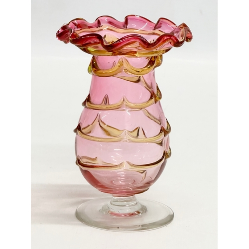 131 - A small Early 20th Century cranberry and amber glass vase. In the manner of Harrach Glass. 8x11cm