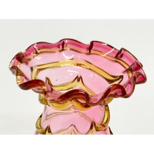 131 - A small Early 20th Century cranberry and amber glass vase. In the manner of Harrach Glass. 8x11cm