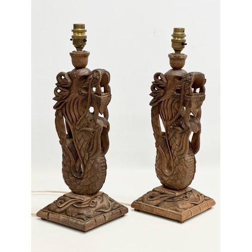 40 - A pair of Early 20th Century Chinese carved teak dragon table lamps. Circa 1920-1930. 15x14x43cm