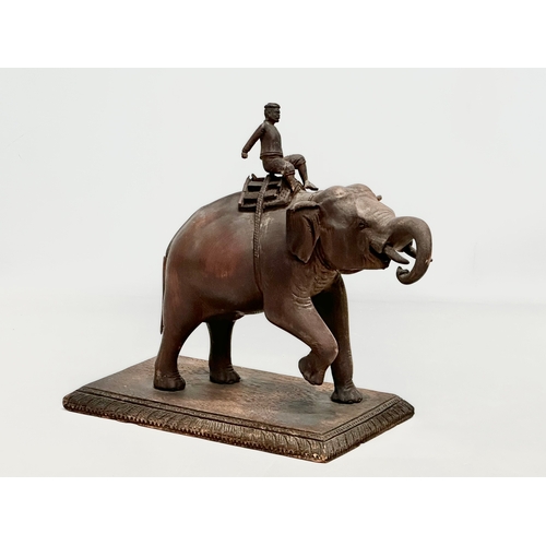 21 - A Late 19th Century carved teak elephant and rider. 31x14.5x26cm