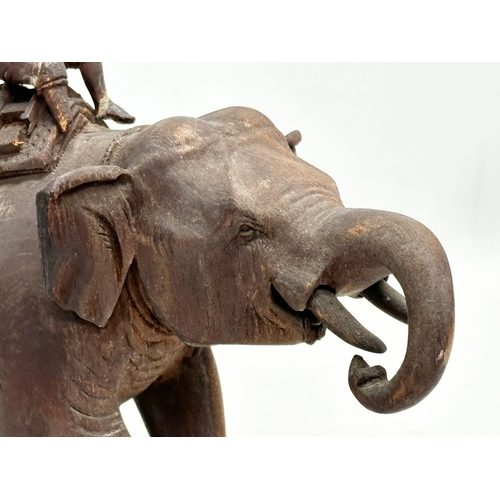 21 - A Late 19th Century carved teak elephant and rider. 31x14.5x26cm