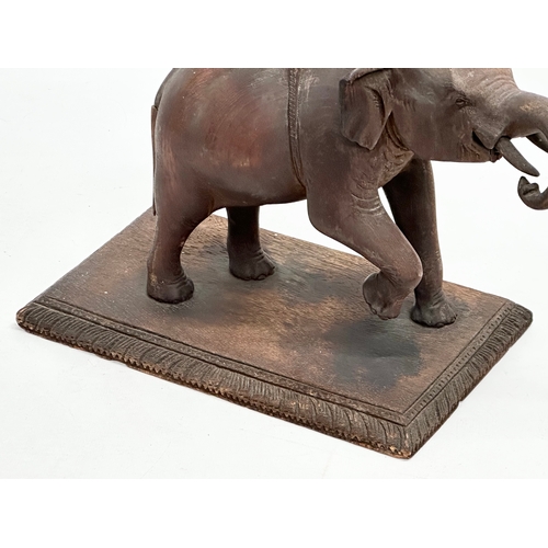 21 - A Late 19th Century carved teak elephant and rider. 31x14.5x26cm