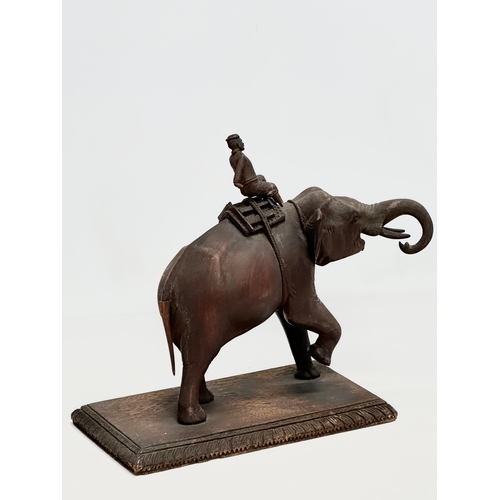 21 - A Late 19th Century carved teak elephant and rider. 31x14.5x26cm