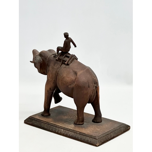 21 - A Late 19th Century carved teak elephant and rider. 31x14.5x26cm