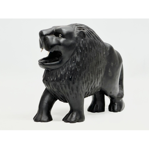 122 - An Early 20th Century coromandel wood lion with bone teeth. 23x21cm