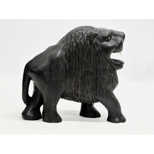 122 - An Early 20th Century coromandel wood lion with bone teeth. 23x21cm