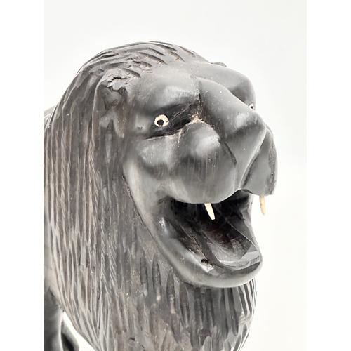 122 - An Early 20th Century coromandel wood lion with bone teeth. 23x21cm