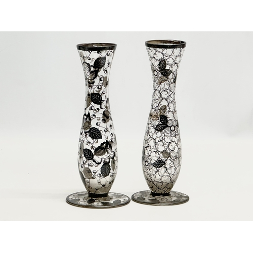 157 - A near pair of Early 20th Century glass vases with hand painted silver overlay. 23cm