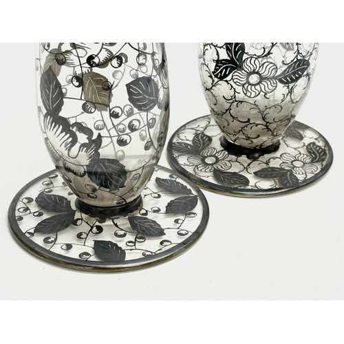 157 - A near pair of Early 20th Century glass vases with hand painted silver overlay. 23cm