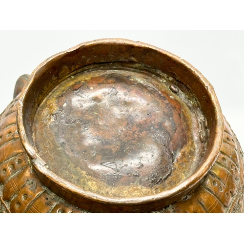 85 - A 19th Century Indian embossed copper holy water vessel and cup. 24x17x18cm.