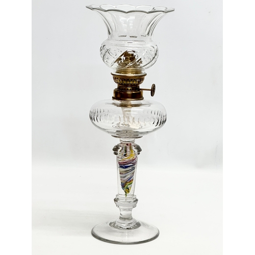 31 - A Late 19th/Early 20th Century glass oil lamp. With multi coloured art glass column. 39cm