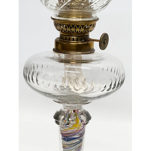 31 - A Late 19th/Early 20th Century glass oil lamp. With multi coloured art glass column. 39cm