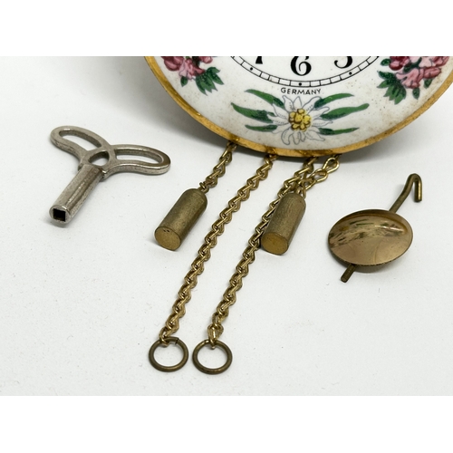 208 - A Mid 20th Century miniature German enamel face wall clock. With original box, key and pendulum. 7cm