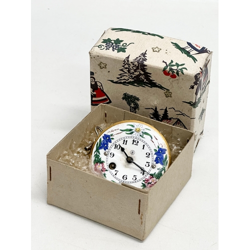 208 - A Mid 20th Century miniature German enamel face wall clock. With original box, key and pendulum. 7cm