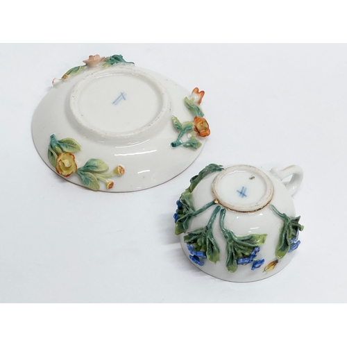 20 - A Late 19th/Early 20th Century, Sitzendorf miniature cup and saucer. Hand painted, with encrusted fl... 