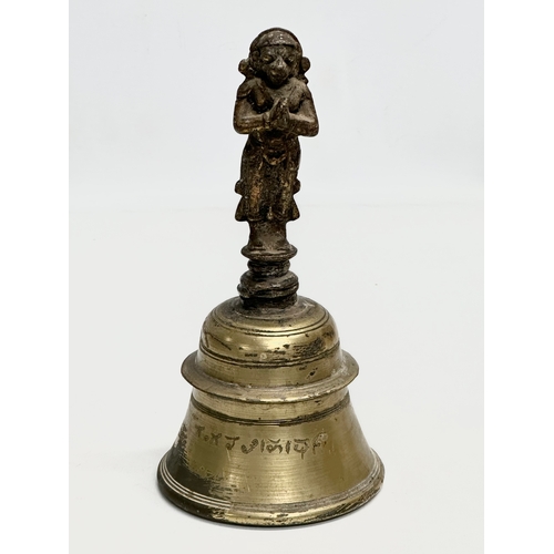 215 - A 19th Century brass Hanuman bell. 21cm