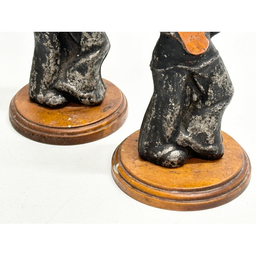 177 - A pair of Early 20th Century cast iron sailors on wooden stands. 20cm