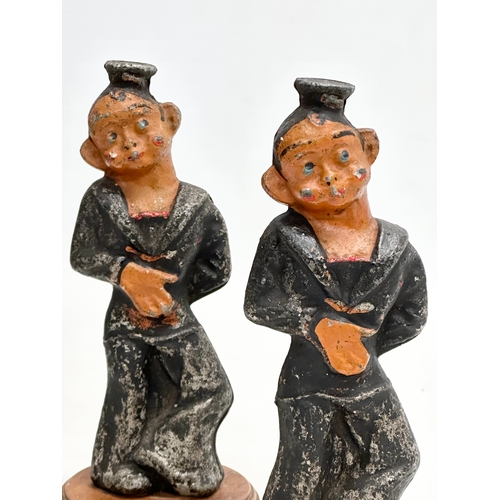 177 - A pair of Early 20th Century cast iron sailors on wooden stands. 20cm