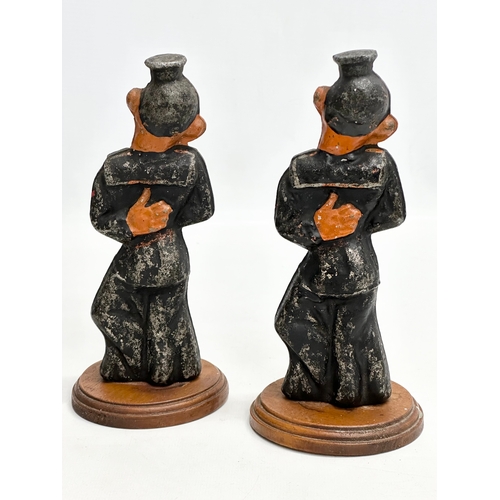 177 - A pair of Early 20th Century cast iron sailors on wooden stands. 20cm