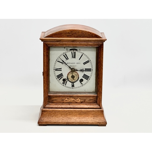 238 - Beringer Bros, Belfast. A Late 19th Century inlaid oak cased mantle clock. By Beringer Bros. With ke... 