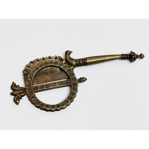 515A - A 19th Century Indian brass betel cutter. 19cm