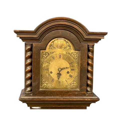 796 - An early 20th century oak long case clock with brass face by Tempus Fugit, in the Jacobean style. Wi... 