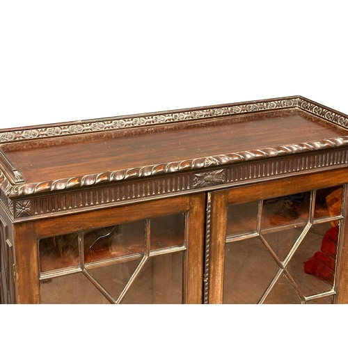 373 - An early 20th century Chippendale Revival mahogany bookcase with astragal doors and carved Ogee Feet... 