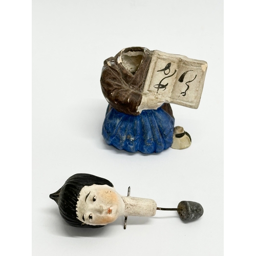 218 - A pair of Early 20th Century Japanese pottery nodder dolls. 8cm.