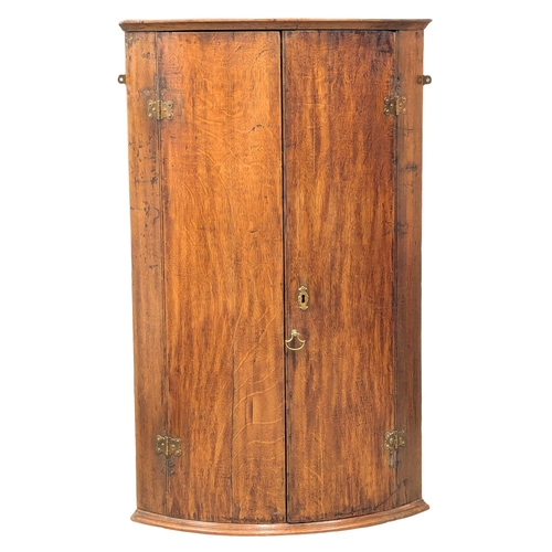 397 - A Late 18th Century George III oak wall hanging corner cupboard with fitted shelves. 65x46x107cm(7)