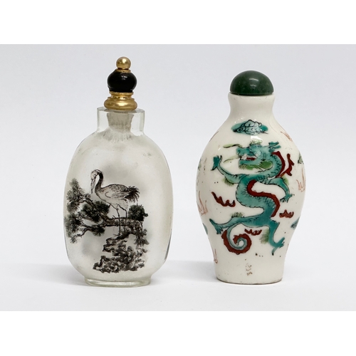 330 - Two Chinese snuff bottles/scent bottles. A hand painted glass Zhou Leyuan style snuff bottle. An Ear... 