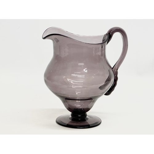 251 - An Early 20th Century George III style amethyst glass water jug. 19x15x20cm.