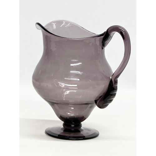 251 - An Early 20th Century George III style amethyst glass water jug. 19x15x20cm.