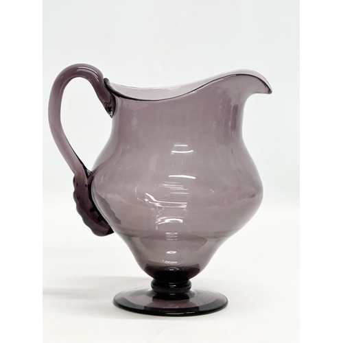 251 - An Early 20th Century George III style amethyst glass water jug. 19x15x20cm.