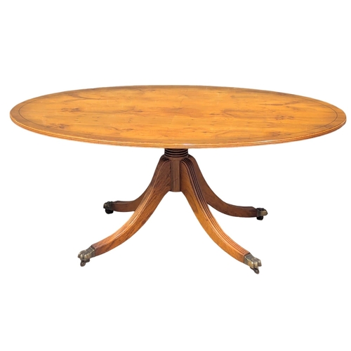 970 - A Georgian style inlaid yew wood pedestal coffee table on brass lion paw feet. 128x76.5x55cm (8)