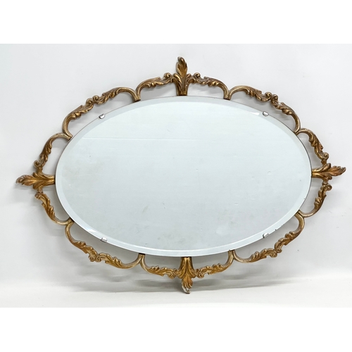 928 - A Mid 20th Century brass framed mirror with bevelled glass. 68x48cm