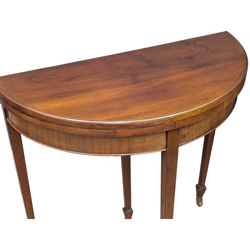 583 - An Early 20th Century Georgian style mahogany demi-lune turnover games table. 85x42x79cm (3)