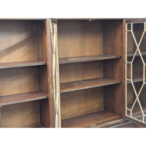 671 - A large Georgian style inlaid mahogany breakfront bookcase with astragal glazed doors. 182x40x208cm.... 